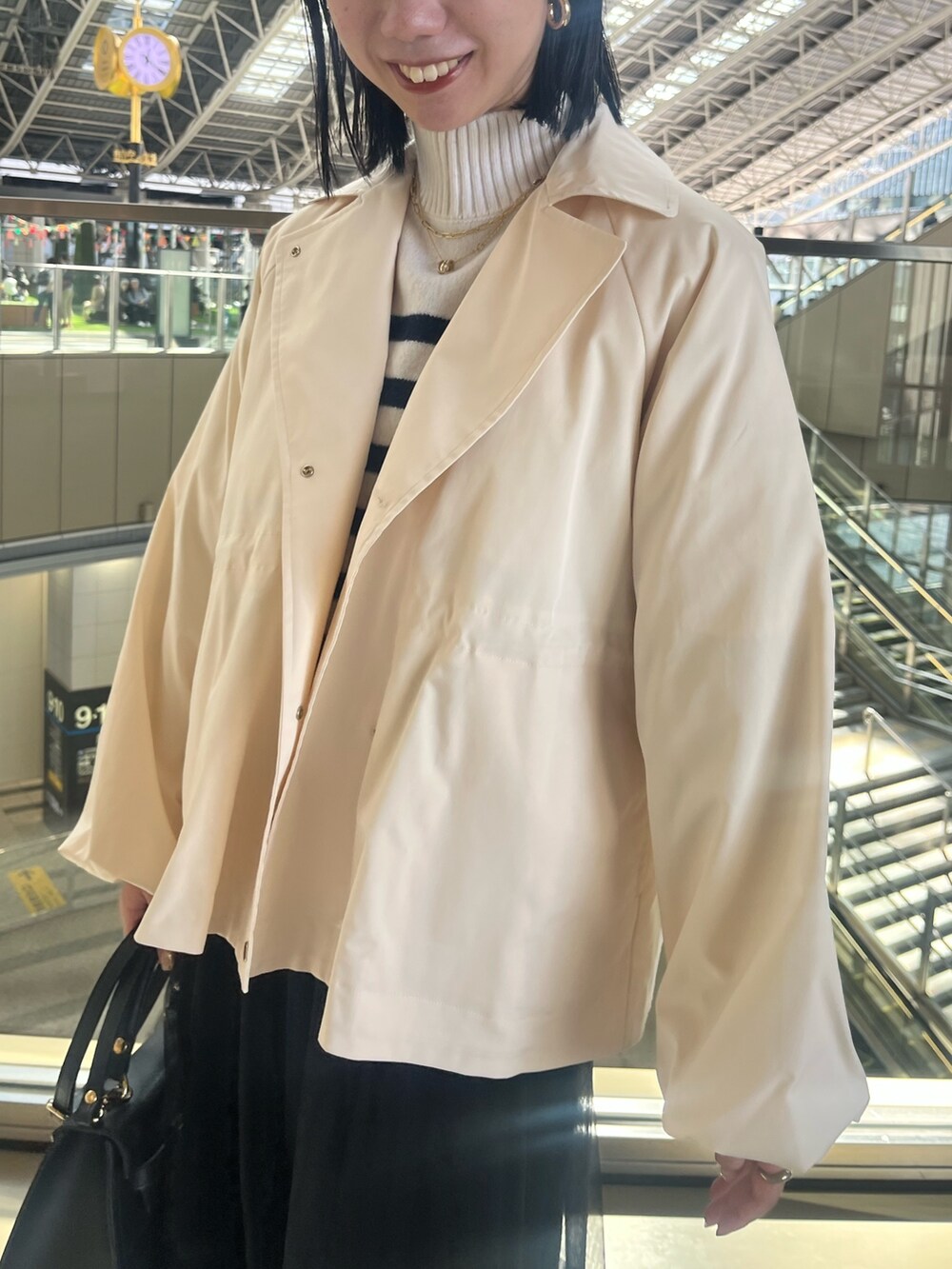 ホワイト系のブルゾン、ブルー系のニット/セーター、ブラック系のスカートを着用したレディースの秋コーディネートの6枚目の写真