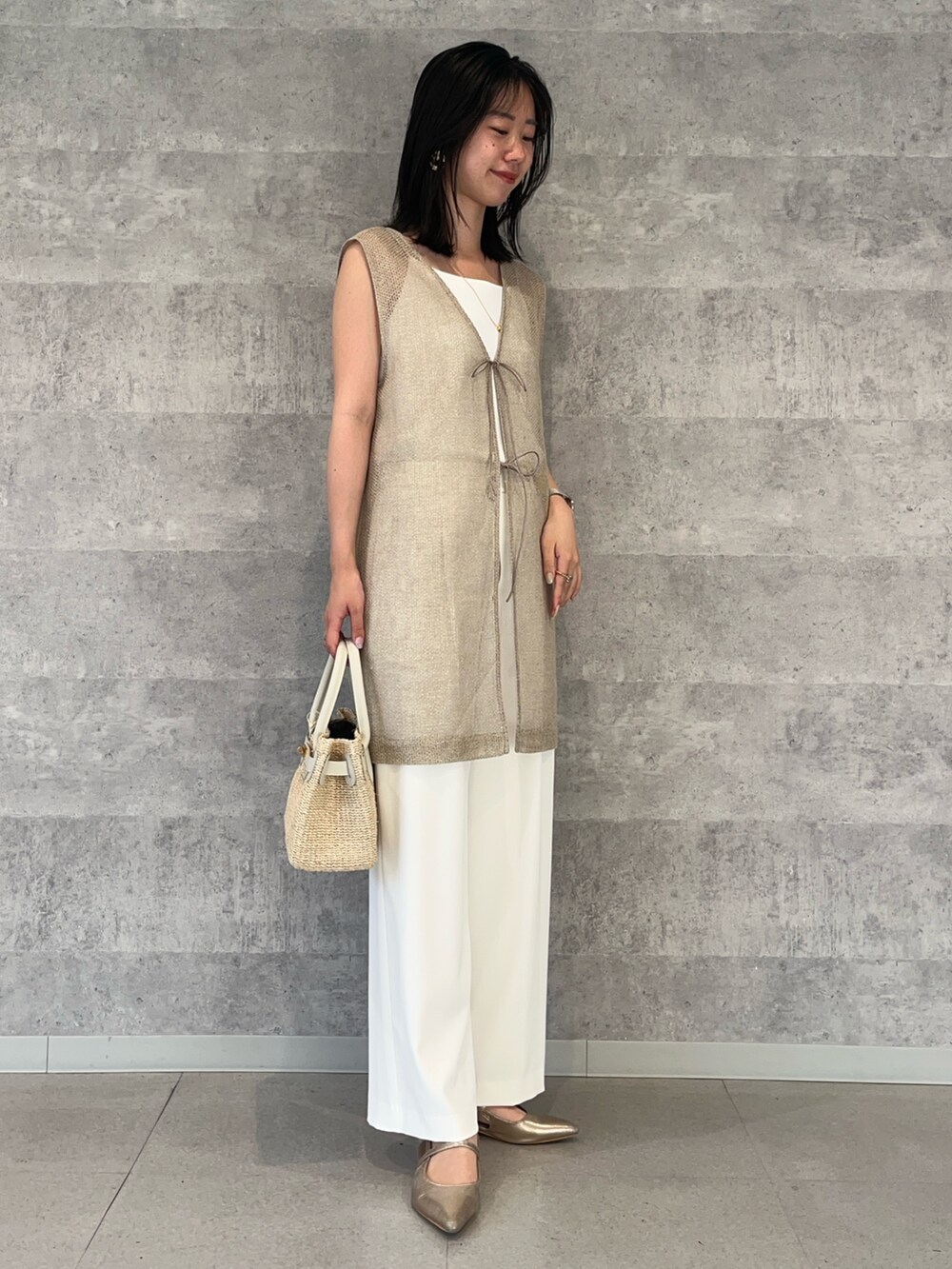 ホワイト系のその他パンツ、ホワイト系のかごバッグ、ホワイト系のキャミソールを着用したレディースの夏コーディネートの5枚目の写真