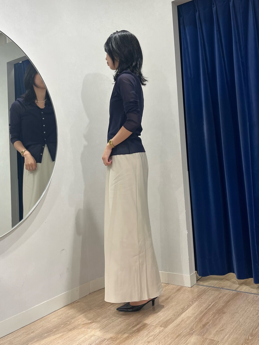 ベージュ系のスカート、ブルー系のカーディガン/ボレロを着用したレディースの秋コーディネートの3枚目の写真