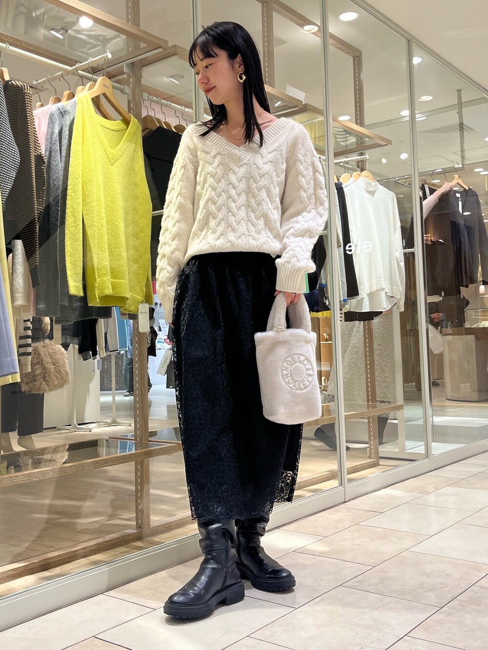 ホワイト系のニット/セーター、ブラック系のスカート、ホワイト系のトートバッグを着用したレディースの冬コーディネートの2枚目の写真