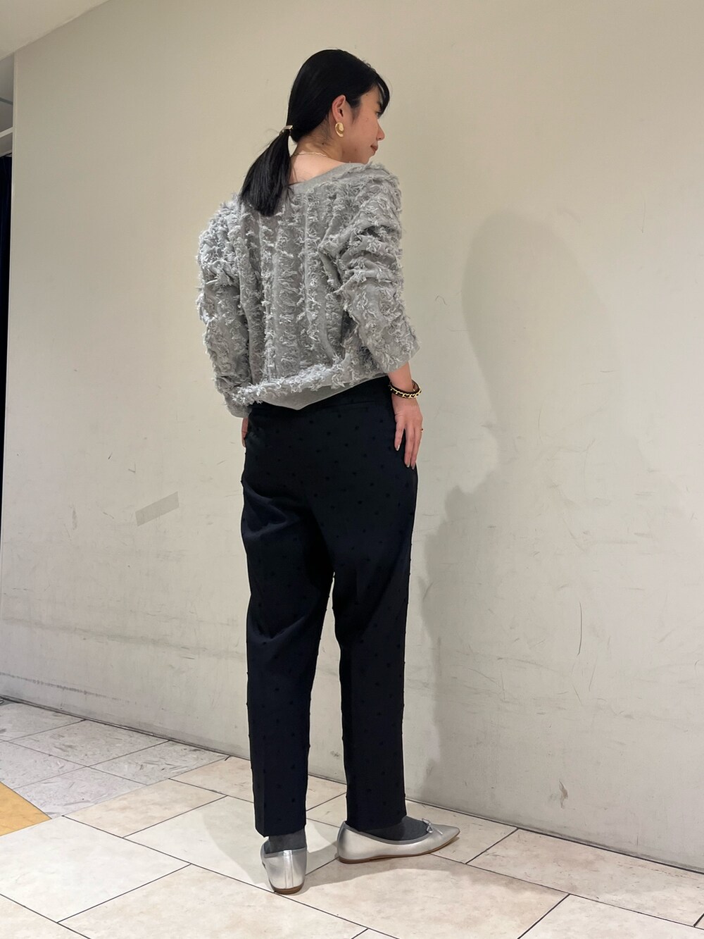 ブラック系のその他パンツ、グレー系のカーディガン/ボレロ、シルバー系のネックレスを着用したレディースの春コーディネートの4枚目の写真