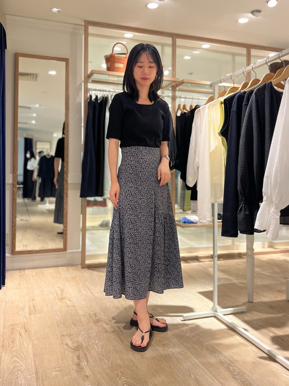 ブラック系のTシャツ/カットソー、ブラック系のスカート、ブラック系のサンダルを着用したレディースの夏コーディネートの2枚目の写真