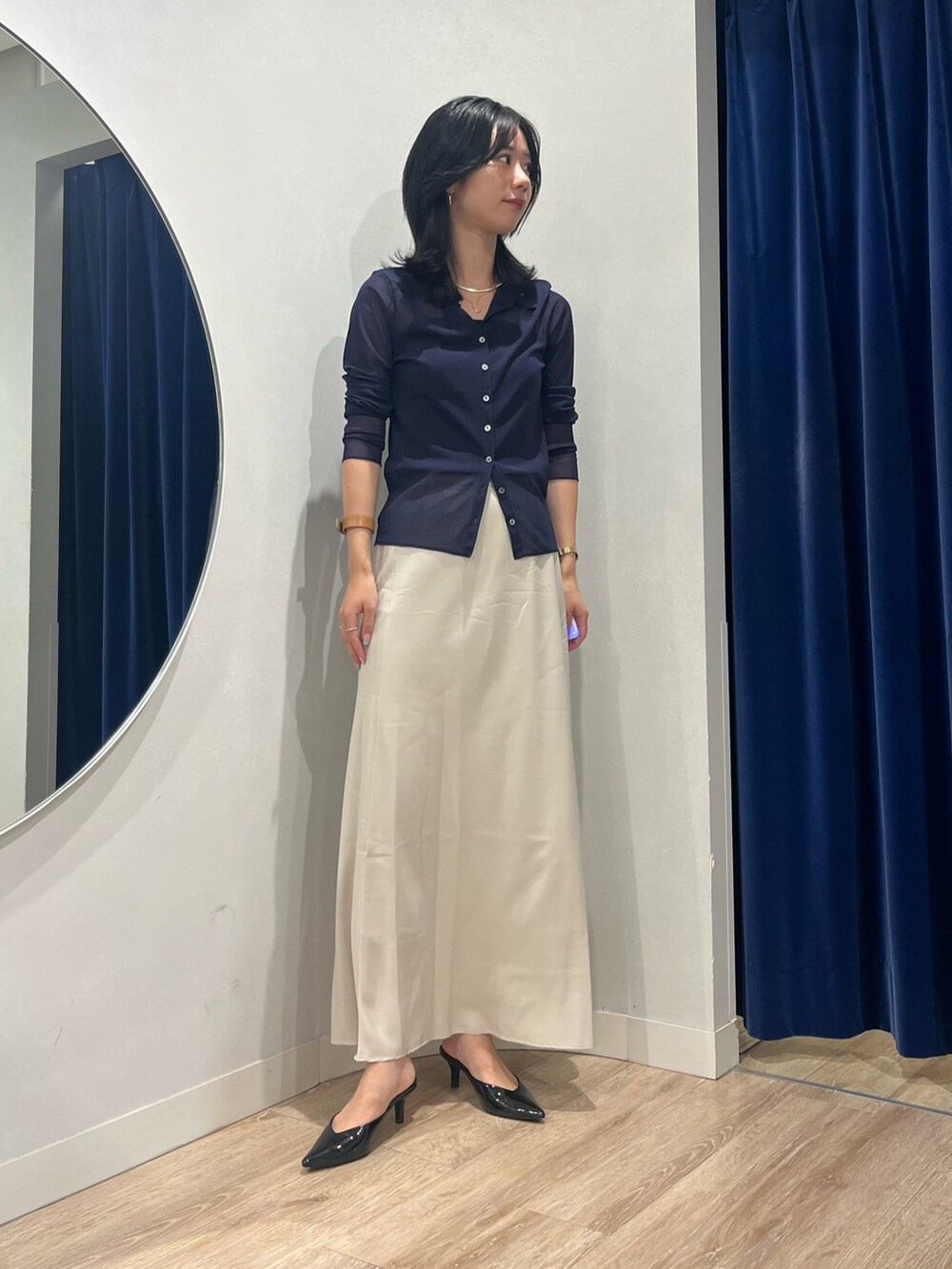 ベージュ系のスカート、ブルー系のカーディガン/ボレロを着用したレディースの秋コーディネートの6枚目の写真