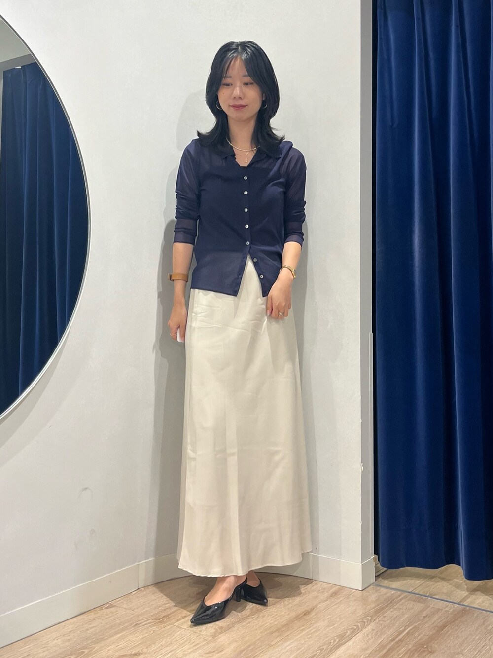 ベージュ系のスカート、ブルー系のカーディガン/ボレロを着用したレディースの秋コーディネートの2枚目の写真