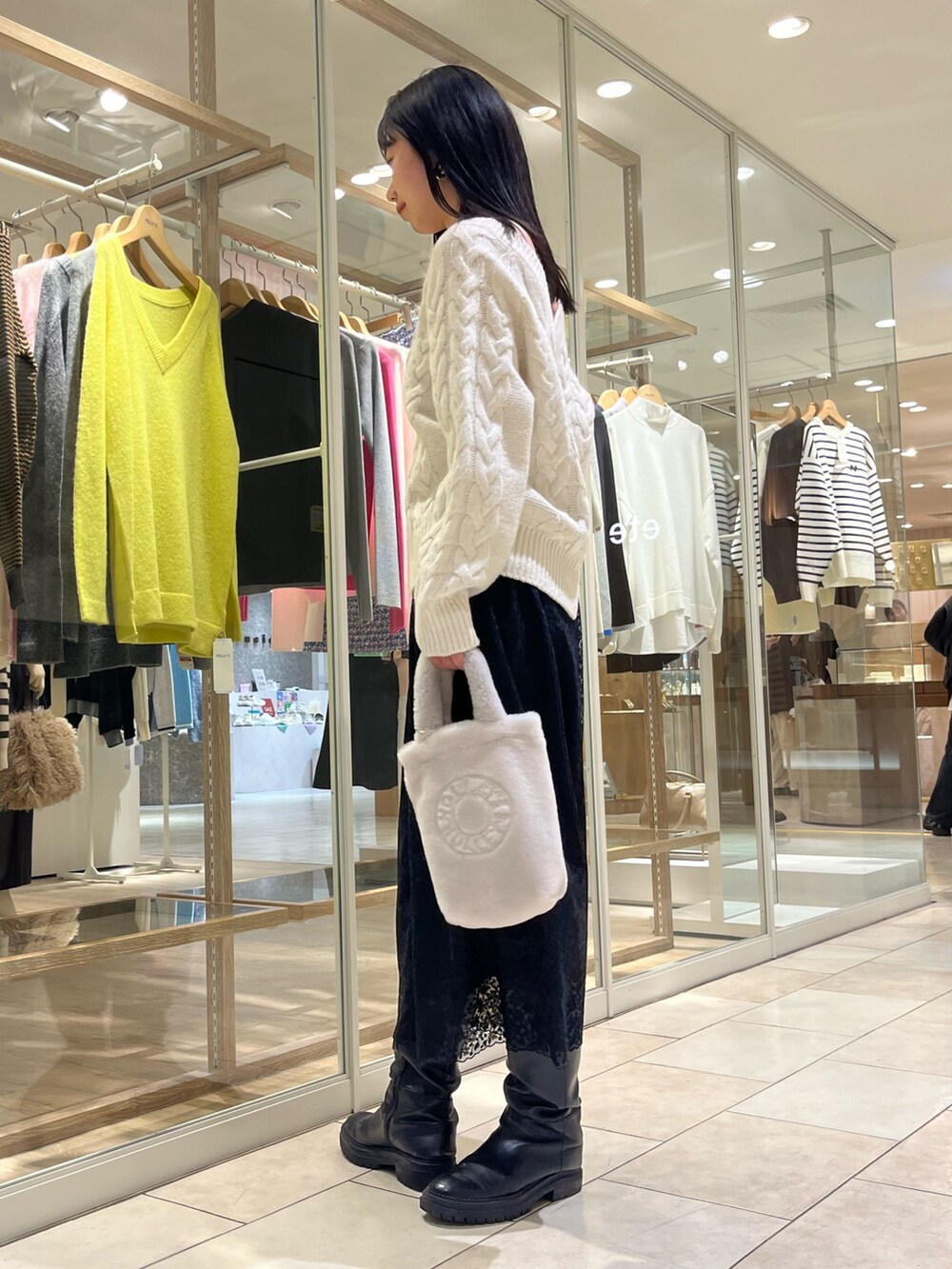 ホワイト系のニット/セーター、ブラック系のスカート、ホワイト系のトートバッグを着用したレディースの冬コーディネートの4枚目の写真