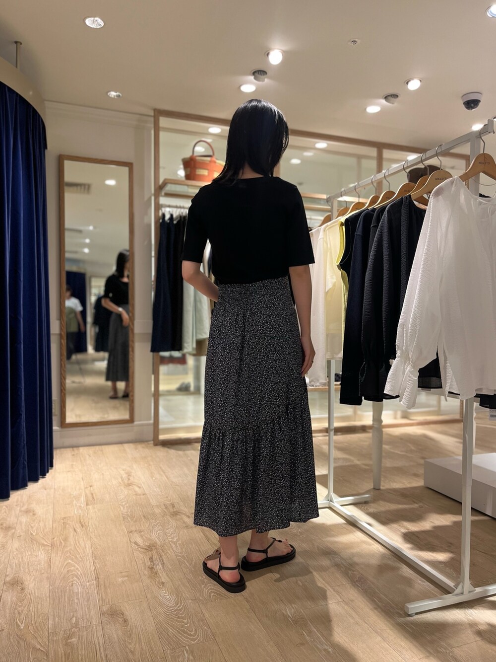 ブラック系のTシャツ/カットソー、ブラック系のスカート、ブラック系のサンダルを着用したレディースの夏コーディネートの4枚目の写真