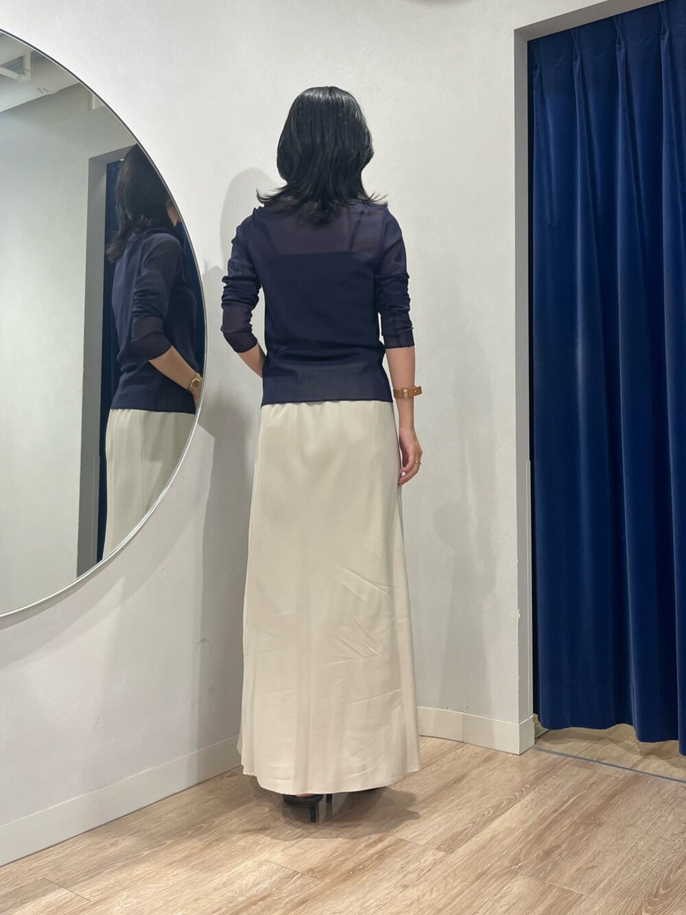 ベージュ系のスカート、ブルー系のカーディガン/ボレロを着用したレディースの秋コーディネートの4枚目の写真