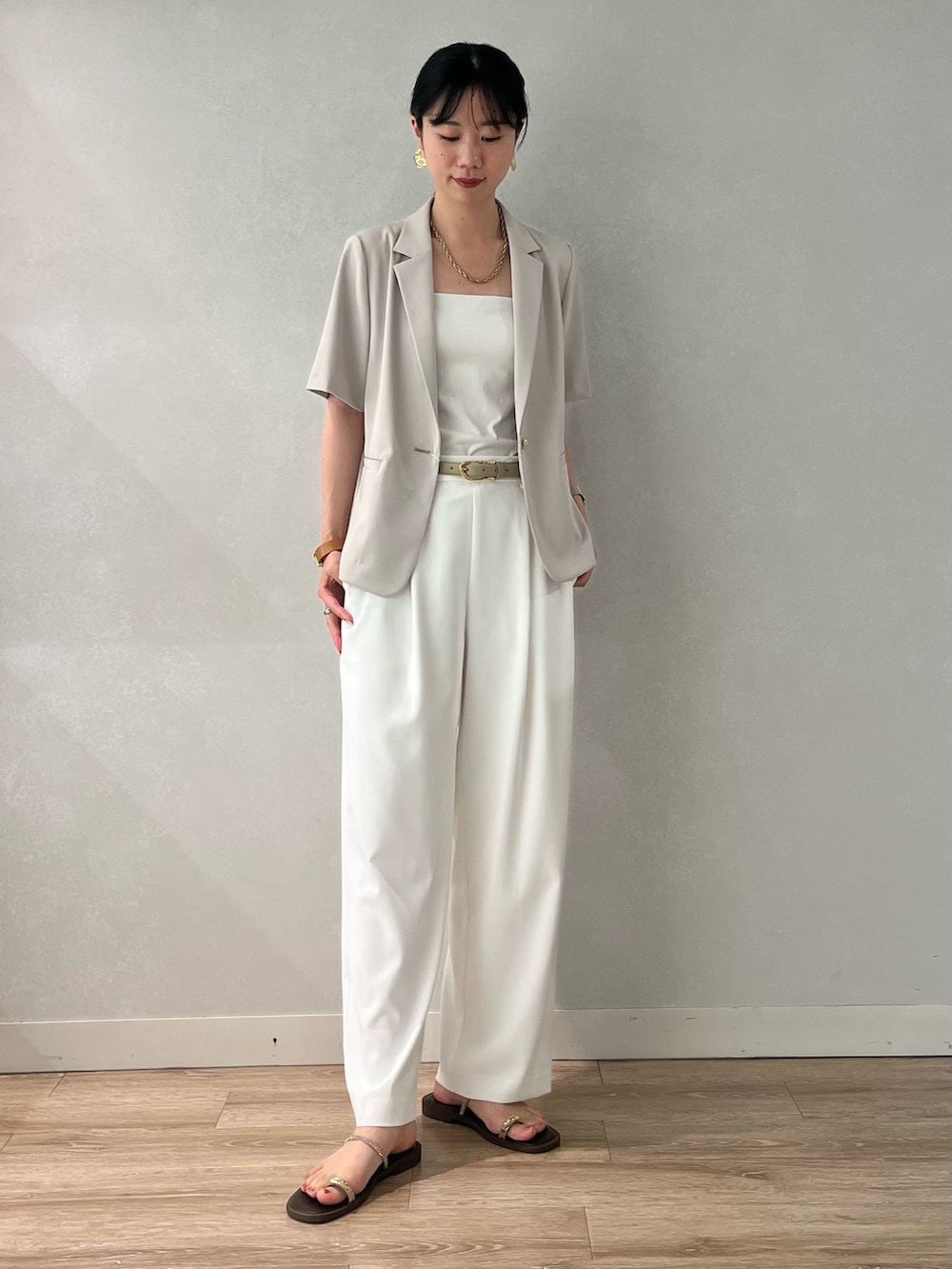 ベージュ系のテーラードジャケット、ホワイト系のその他パンツ、ブラウン系のサンダルを着用したレディースの夏コーディネートの6枚目の写真