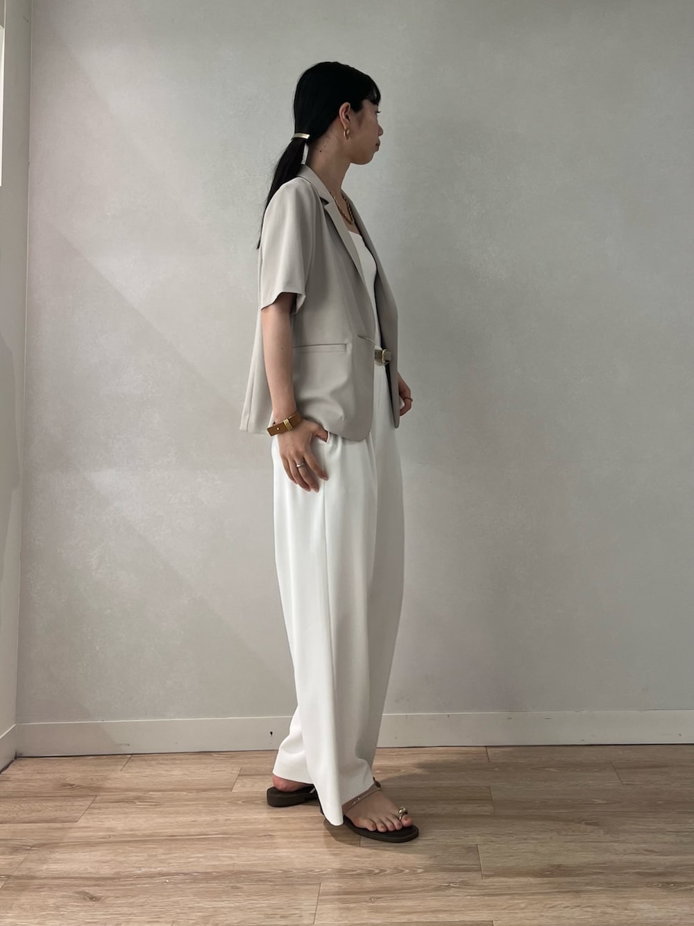 ベージュ系のテーラードジャケット、ホワイト系のその他パンツ、ブラウン系のサンダルを着用したレディースの夏コーディネートの3枚目の写真