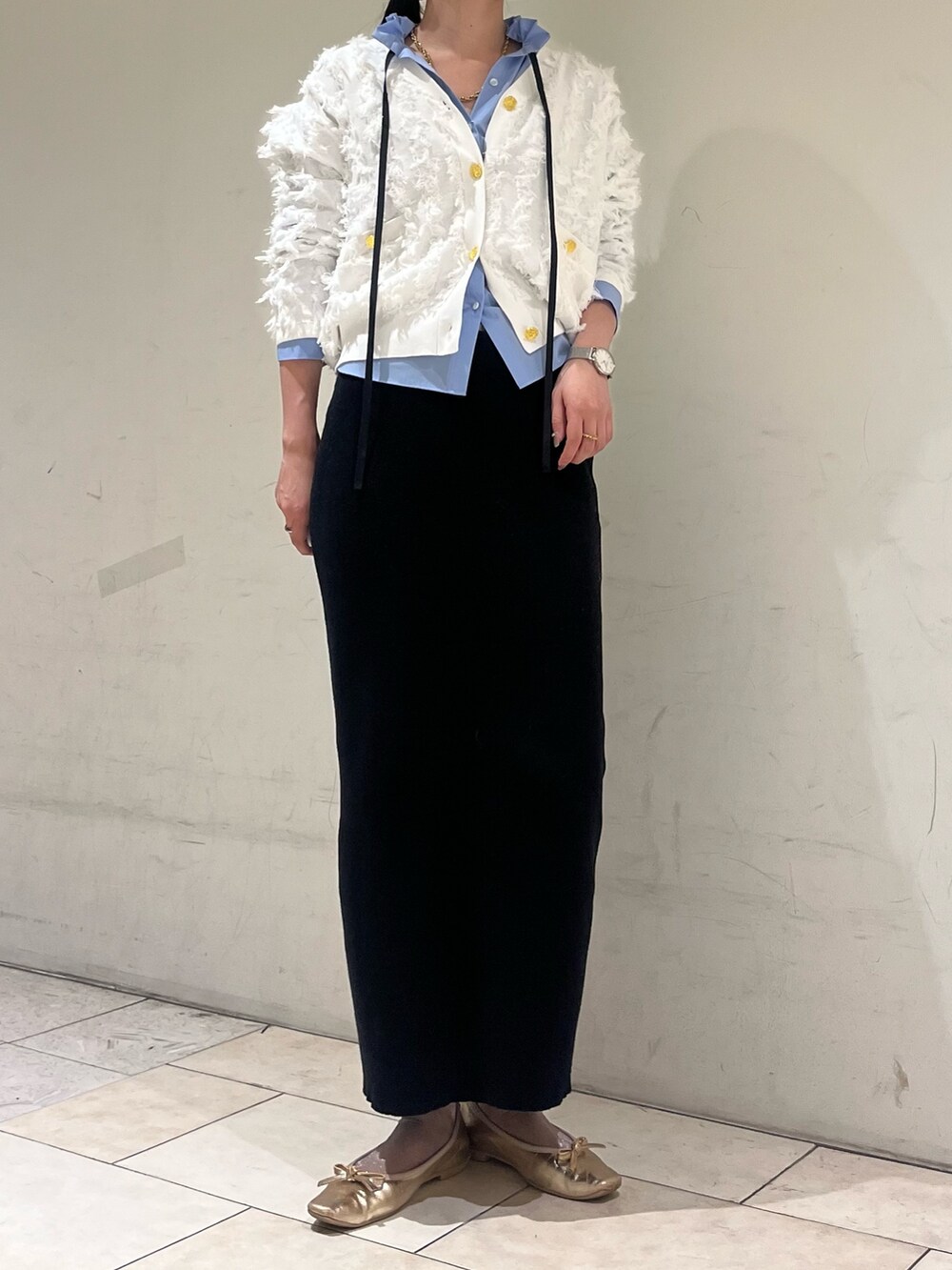 ブラック系のスカート、ブルー系のシャツ/ブラウス、ホワイト系のカーディガン/ボレロを着用したレディースの冬コーディネートの6枚目の写真