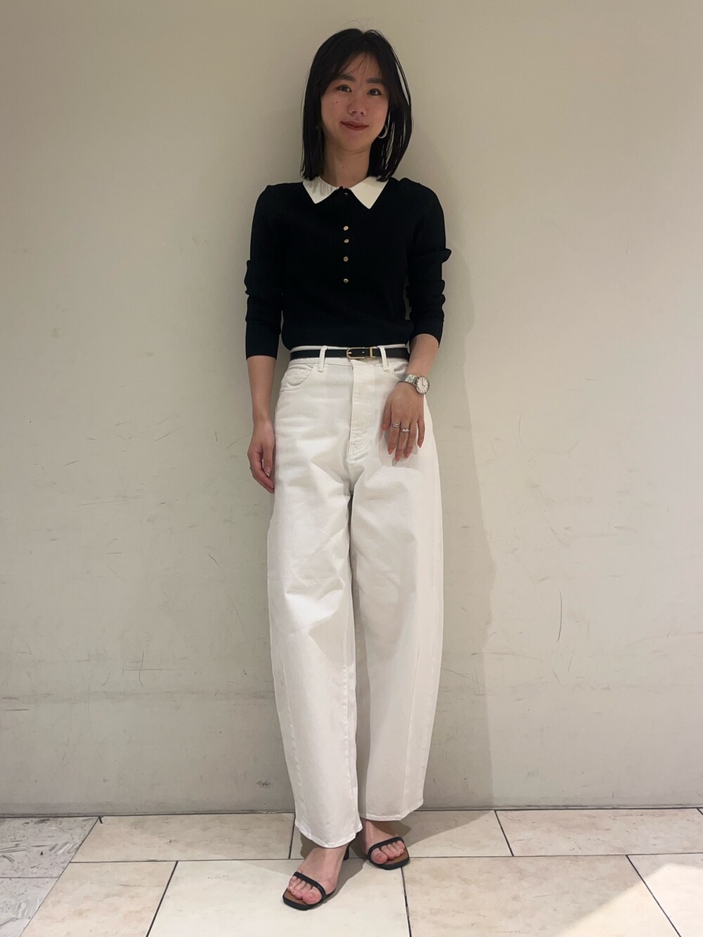 ブラック系のニット/セーター、ホワイト系のデニムパンツ、ブラック系のベルトを着用したレディースの冬コーディネートの6枚目の写真