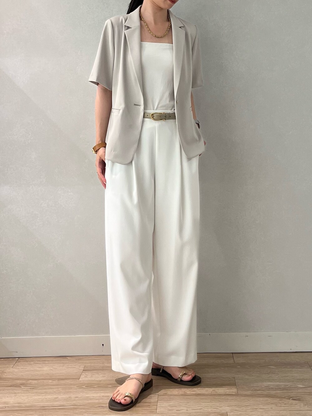 ベージュ系のテーラードジャケット、ホワイト系のその他パンツ、ブラウン系のサンダルを着用したレディースの夏コーディネートの5枚目の写真