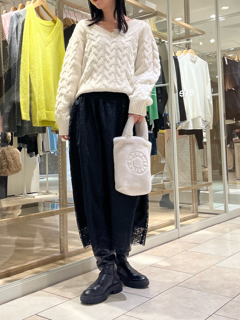 ホワイト系のニット/セーター、ブラック系のスカート、ホワイト系のトートバッグを着用したレディースの冬コーディネートの3枚目の写真