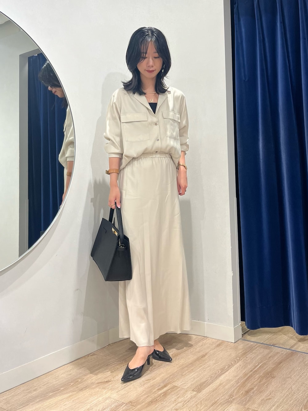 ベージュ系のスカート、ベージュ系のシャツ/ブラウス、ブラック系のショルダーバッグを着用したレディースの秋コーディネートの6枚目の写真