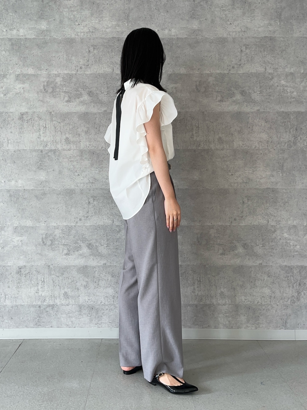 グレー系のその他パンツ、ホワイト系のシャツ/ブラウス、ブラック系のパンプスを着用したレディースの夏コーディネートの4枚目の写真