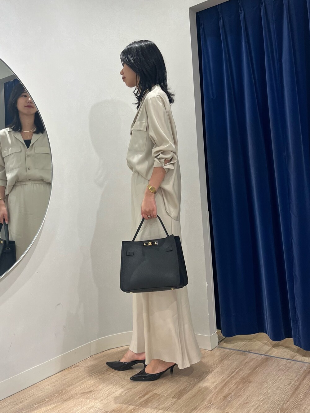 ベージュ系のスカート、ベージュ系のシャツ/ブラウス、ブラック系のショルダーバッグを着用したレディースの秋コーディネートの3枚目の写真