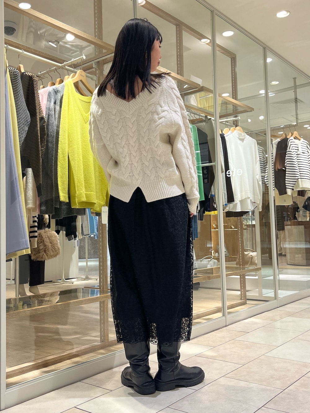 ホワイト系のニット/セーター、ブラック系のスカート、ホワイト系のトートバッグを着用したレディースの冬コーディネートの5枚目の写真