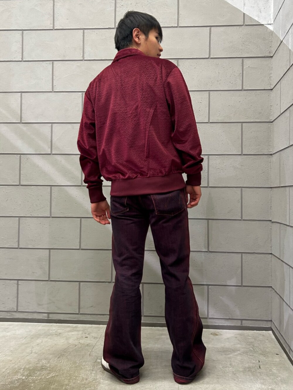 ホワイト系のシューズ、レッド系のジャージを着用したメンズの冬コーディネートの2枚目の写真