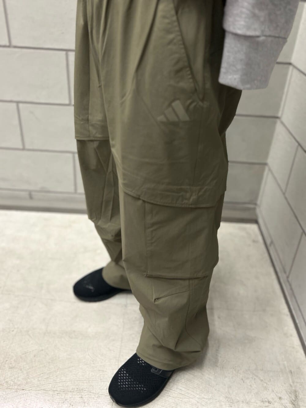 ブラック系のスニーカー、グリーン系のその他パンツ、ブラック系のキャップを着用したメンズの冬コーディネートの3枚目の写真