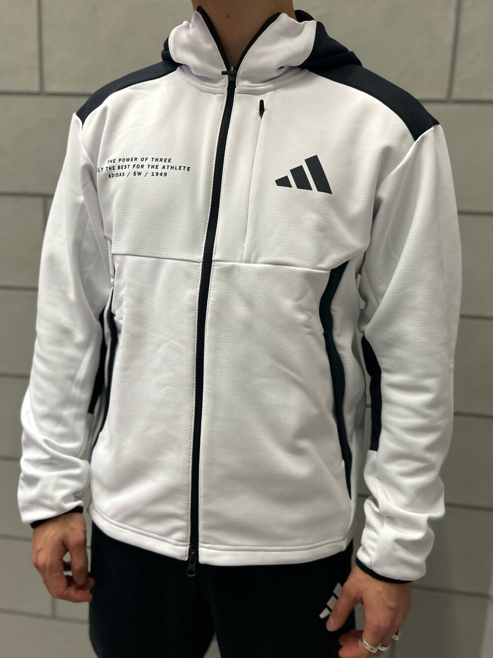 ホワイト系のパーカー、ブラック系のスウェットパンツ、ブラック系のスニーカーを着用したメンズの冬コーディネートの2枚目の写真