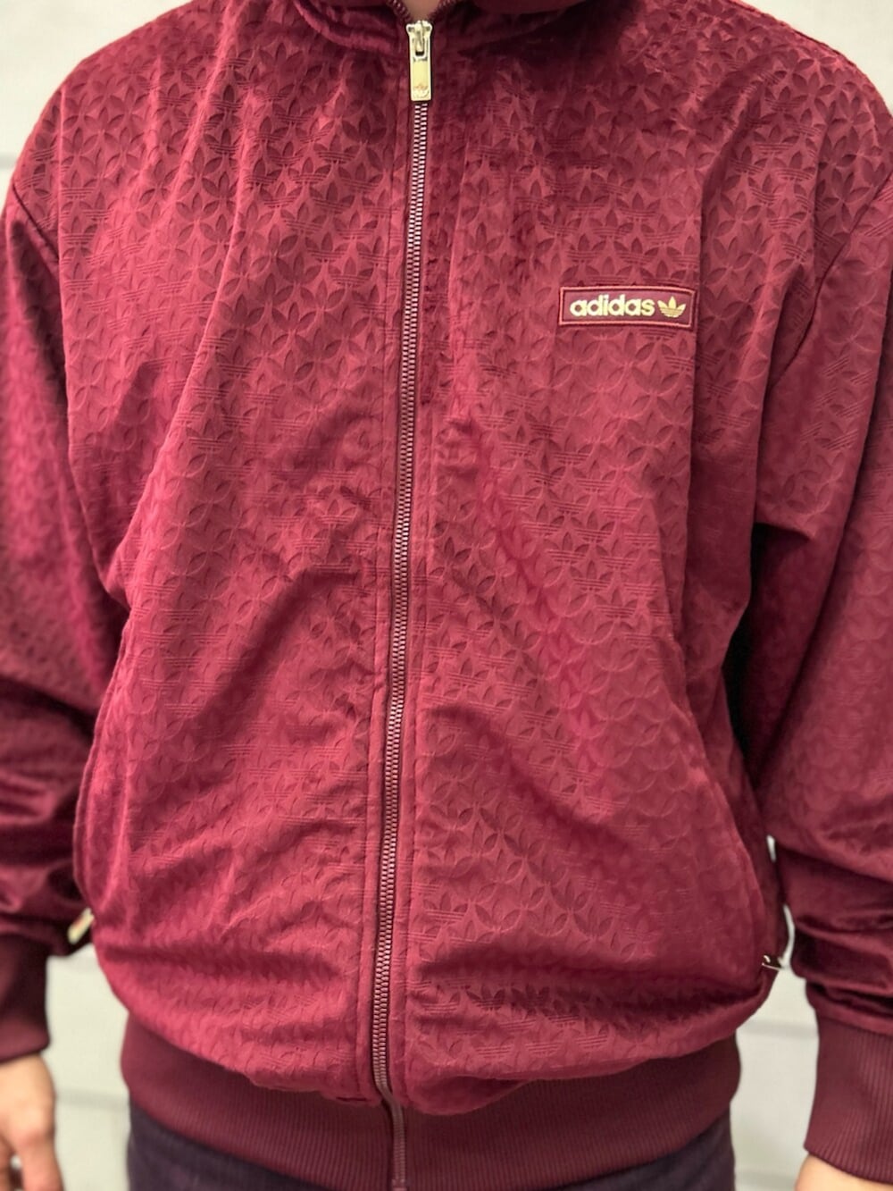 ホワイト系のシューズ、レッド系のジャージを着用したメンズの冬コーディネートの3枚目の写真