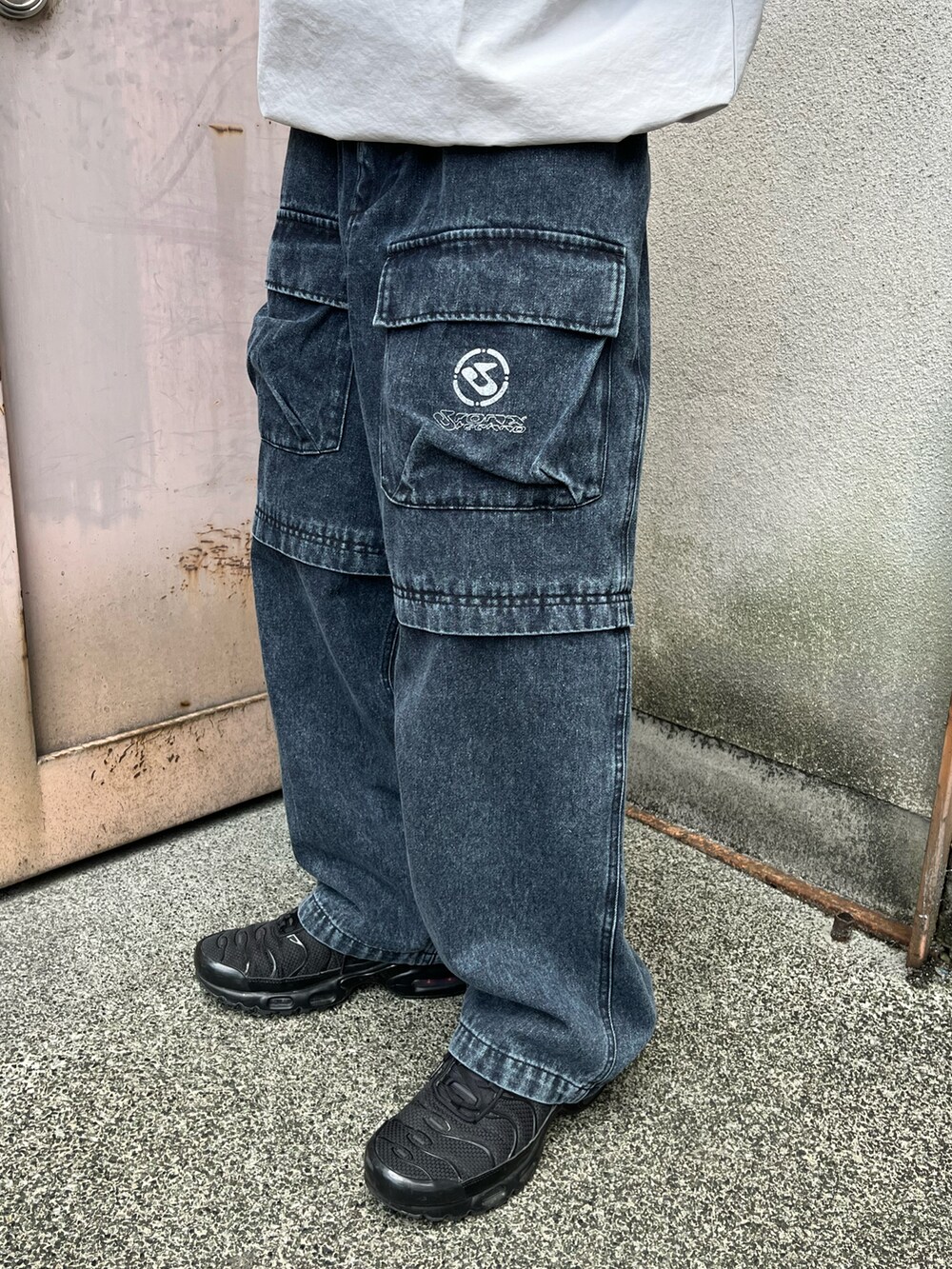 グレー系のTシャツ/カットソー、ブルー系のカーゴパンツ、ブラック系のスニーカーを着用したメンズの春コーディネートの4枚目の写真