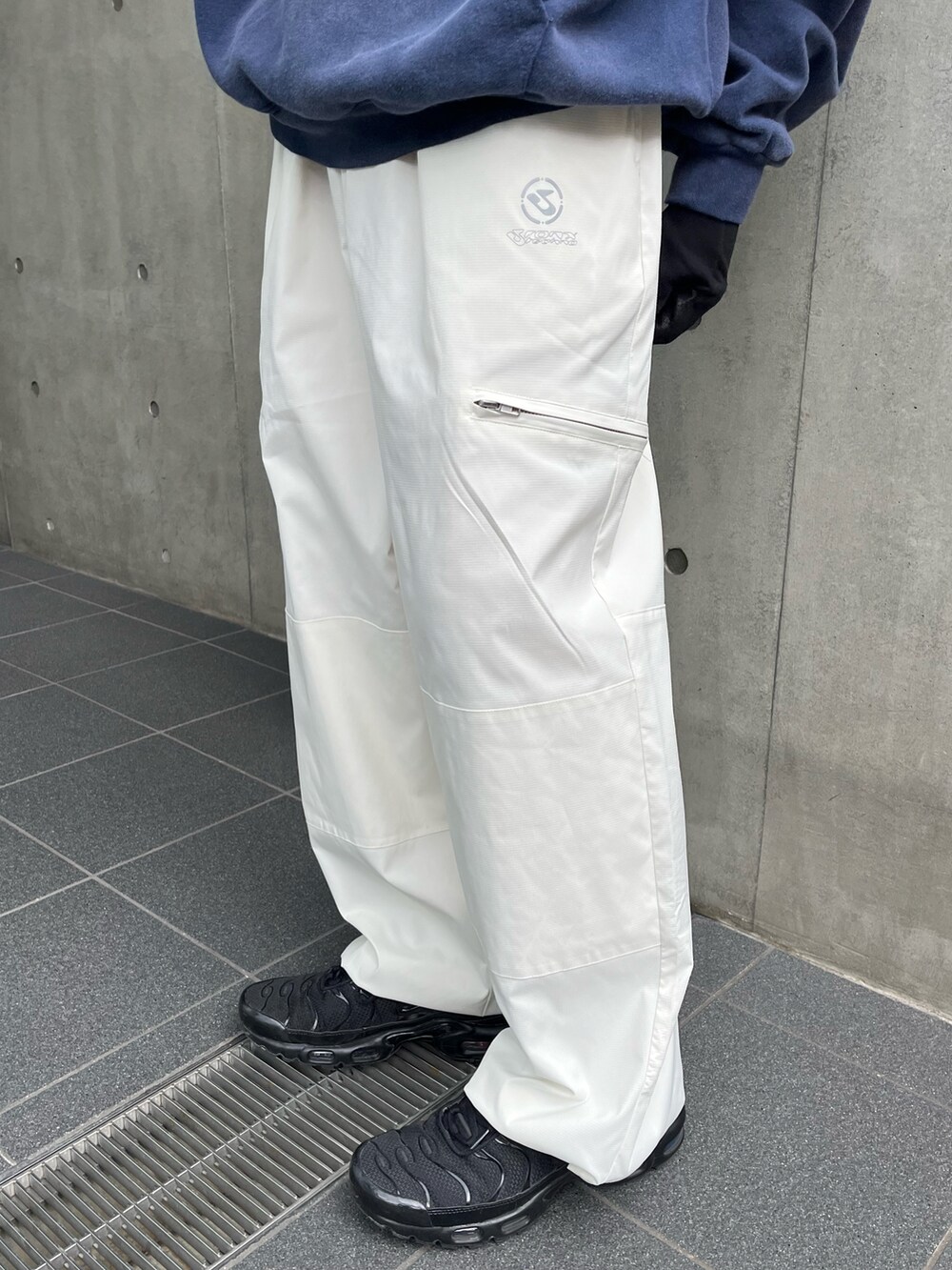 ブルー系のパーカー、ホワイト系のチノパンツ、ブラック系のスニーカーを着用したメンズの冬コーディネートの4枚目の写真