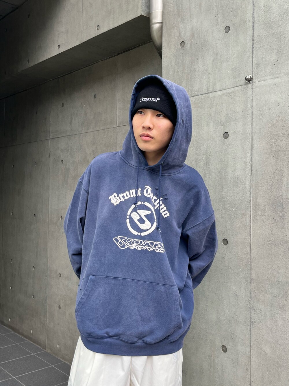 ブルー系のパーカー、ホワイト系のチノパンツ、ブラック系のスニーカーを着用したメンズの冬コーディネートの3枚目の写真