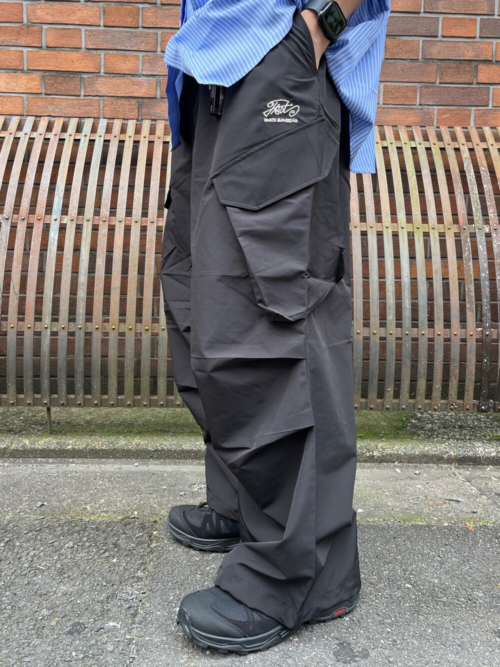 ブルー系のシャツ/ブラウス、ブラック系のカーゴパンツ、ブラック系のスニーカーを着用したメンズの春コーディネートの4枚目の写真