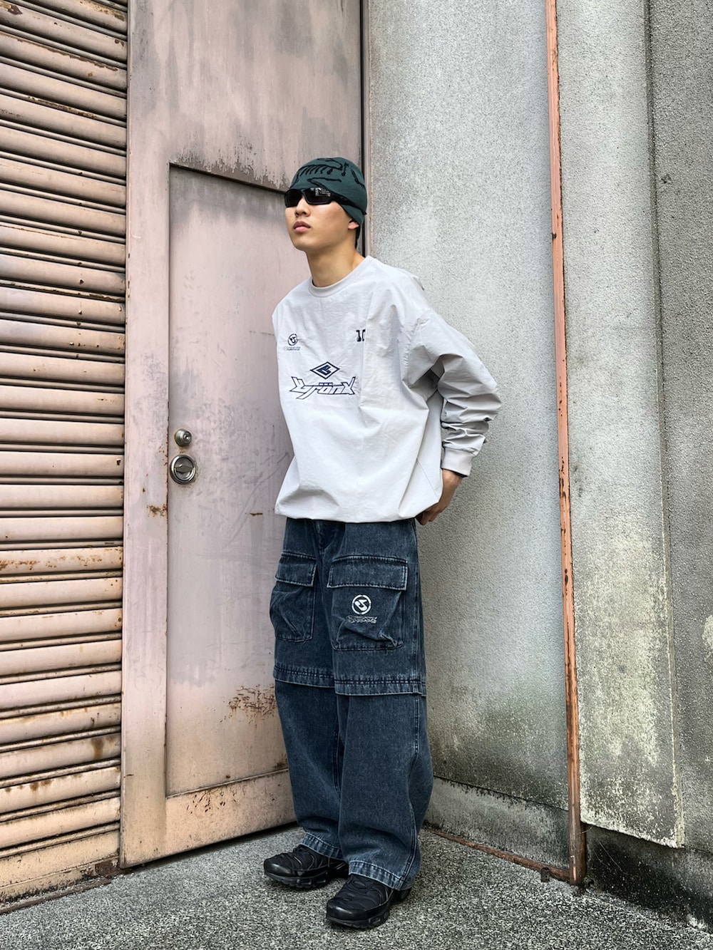 グレー系のTシャツ/カットソー、ブルー系のカーゴパンツ、ブラック系のスニーカーを着用したメンズの春コーディネートの2枚目の写真