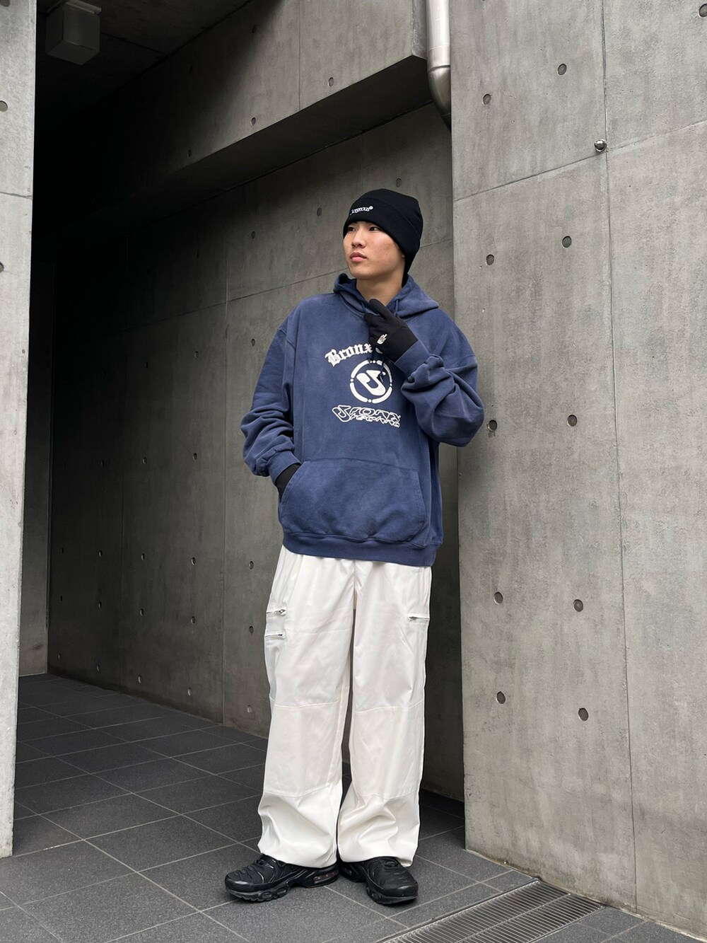 ブルー系のパーカー、ホワイト系のチノパンツ、ブラック系のスニーカーを着用したメンズの冬コーディネートの2枚目の写真