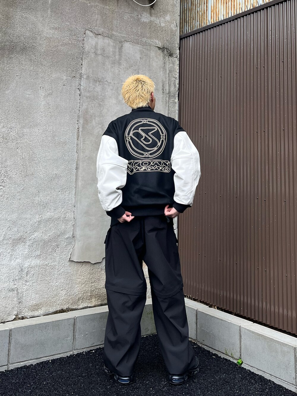 ホワイト系のジャケット/アウター、ブラック系のカーゴパンツ、ブラック系のスニーカーを着用したメンズの冬コーディネートの2枚目の写真