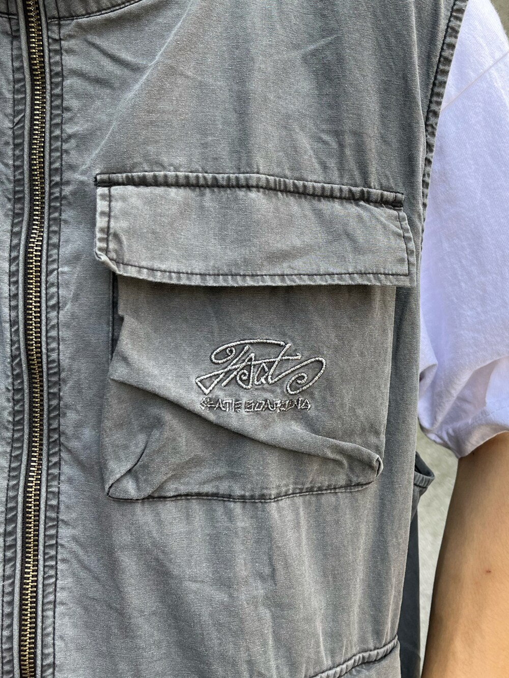 グレー系のベスト、ブラック系のカーゴパンツ、ブラック系のモカシン/デッキシューズを着用したメンズの夏コーディネートの4枚目の写真