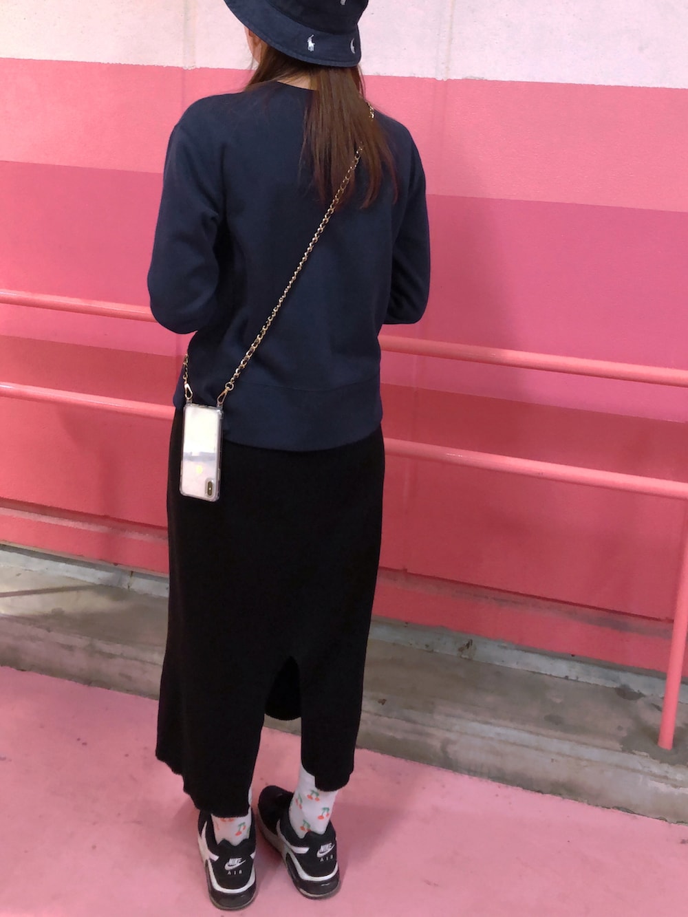 ブラック系のスカート、ブラック系のスニーカー、ブラック系のスウェットを着用したレディースの春コーディネートの2枚目の写真