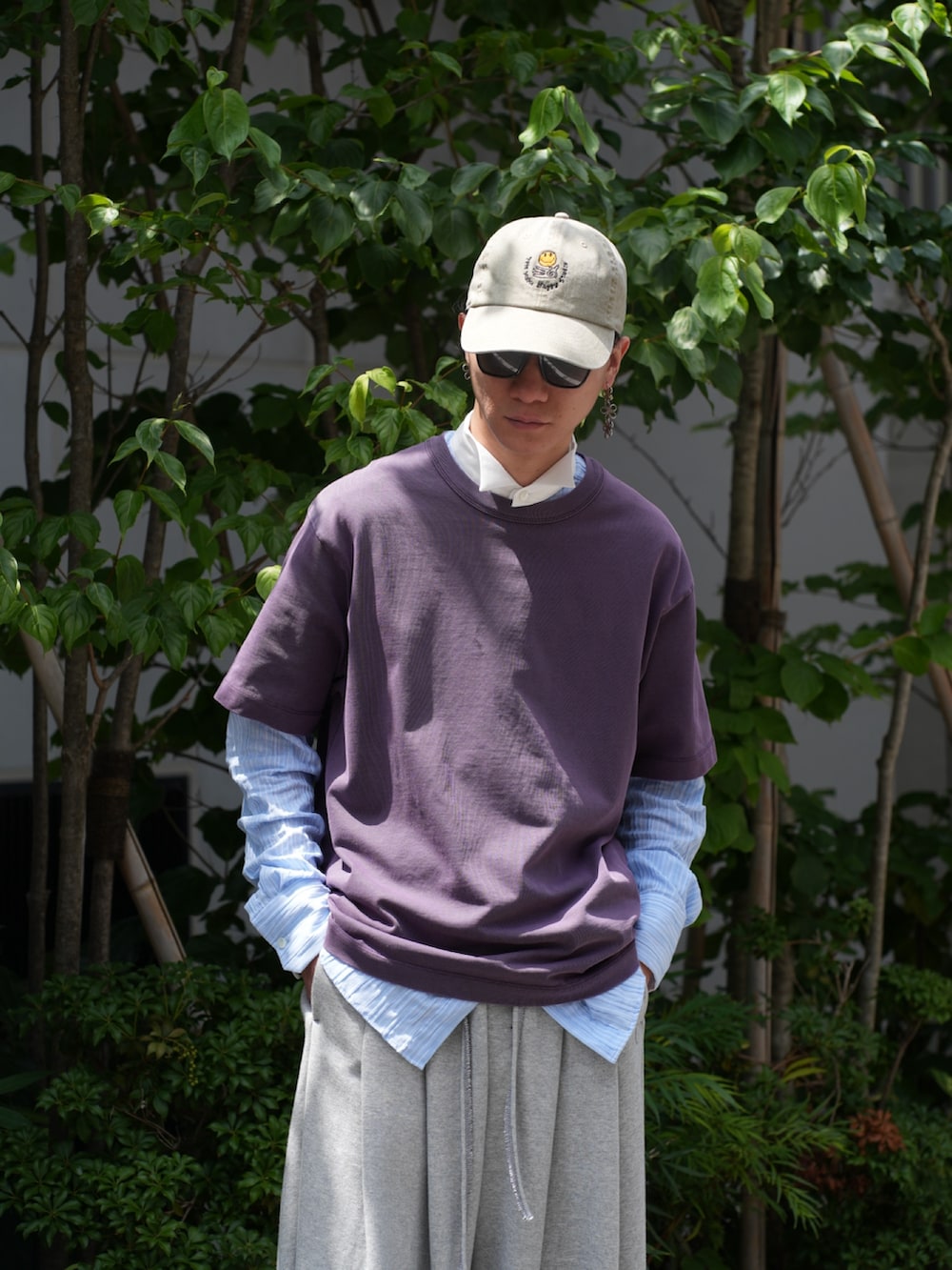 パープル系のTシャツ/カットソー、グレー系のその他パンツ、ベージュ系のキャップを着用したメンズの夏コーディネートの4枚目の写真