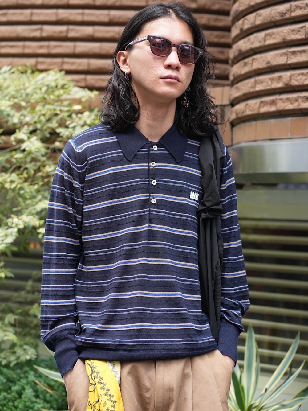 ブラック系のトートバッグ、イエロー系のその他パンツ、レッド系のスニーカーを着用したメンズの夏コーディネートの3枚目の写真