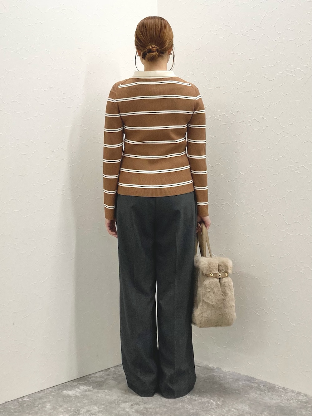 グレー系のその他パンツ、ブラウン系のニット/セーター、ベージュ系のトートバッグを着用したレディースの秋コーディネートの4枚目の写真
