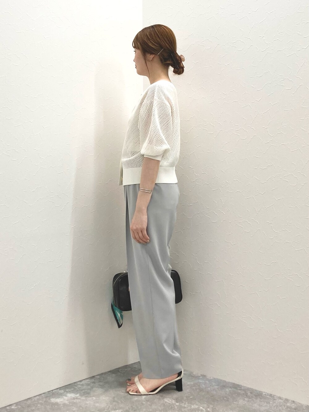 ホワイト系のカーディガン/ボレロ、グレー系のその他パンツ、ブラック系のボストンバッグを着用したレディースの春コーディネートの3枚目の写真