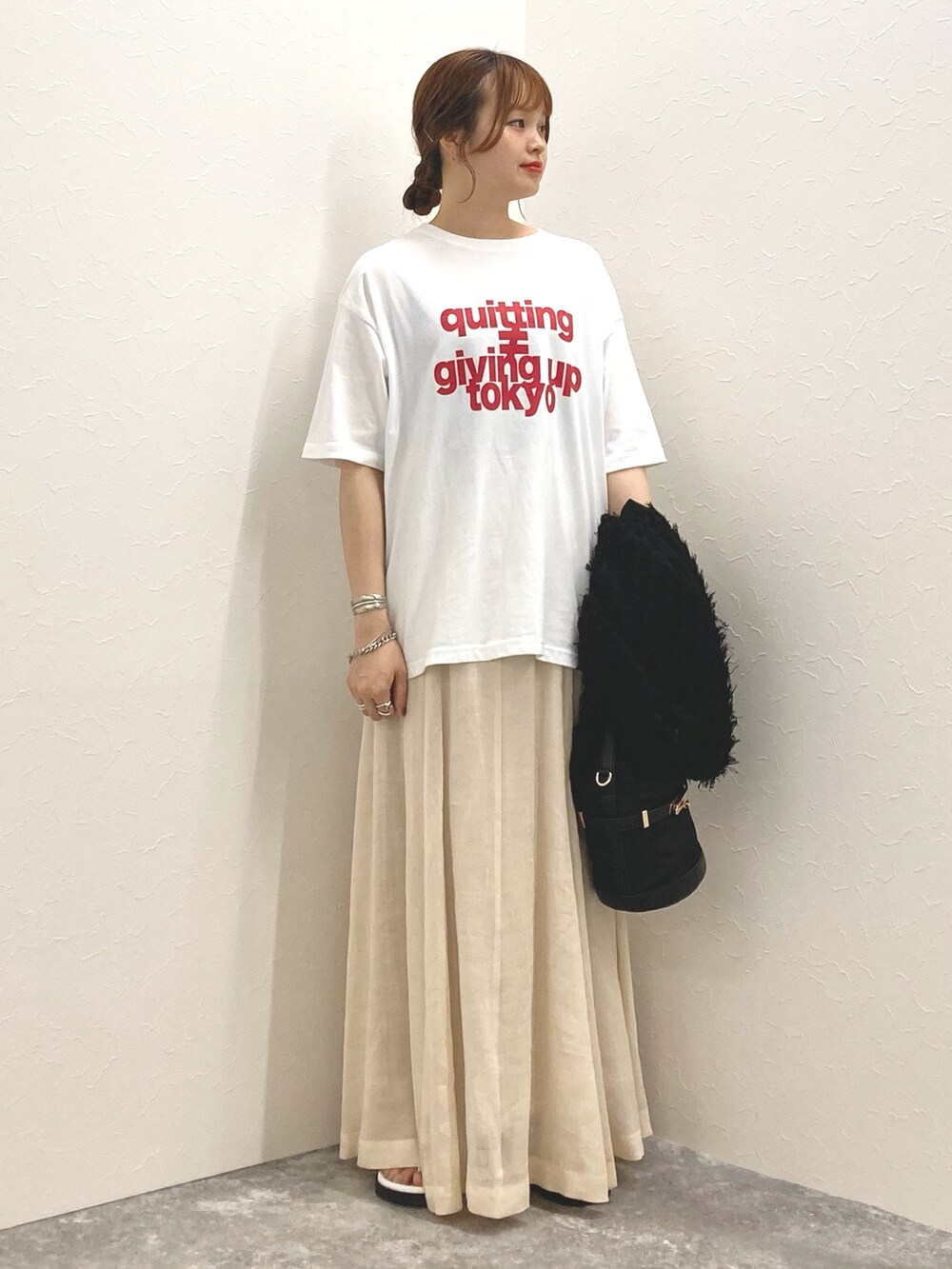 ホワイト系のTシャツ/カットソー、ベージュ系のスカート、ブラック系のカーディガン/ボレロを着用したレディースの夏コーディネートの7枚目の写真