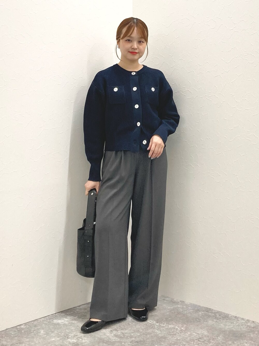 ブラック系のショルダーバッグ、ブラック系のパンプス、ブルー系のカーディガン/ボレロを着用したレディースの秋コーディネートの2枚目の写真