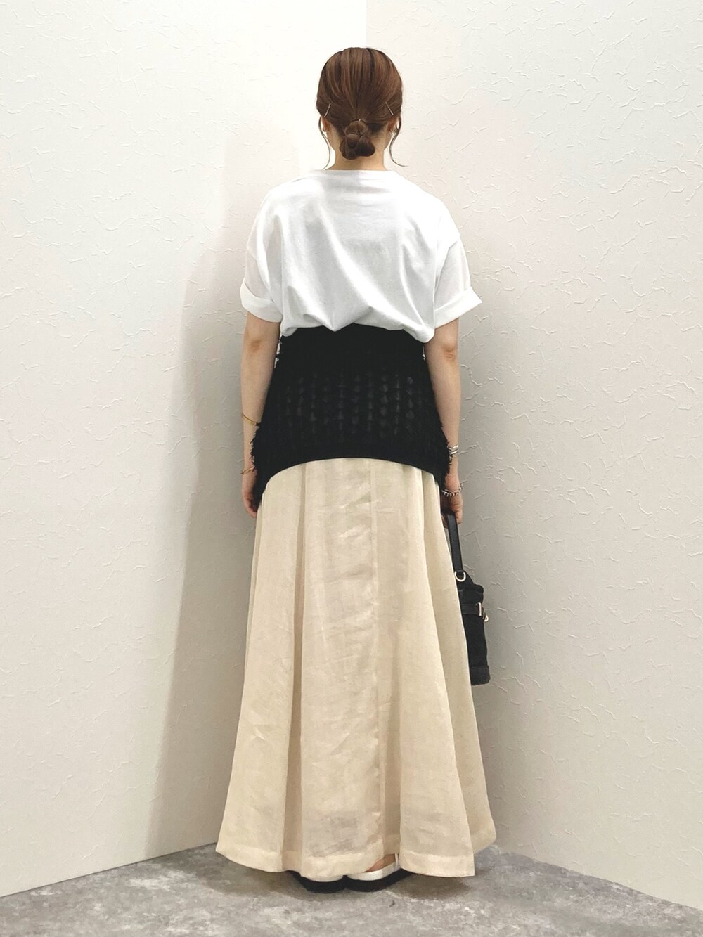 ホワイト系のTシャツ/カットソー、ベージュ系のスカート、ブラック系のカーディガン/ボレロを着用したレディースの夏コーディネートの3枚目の写真