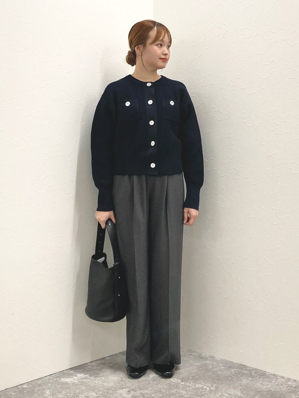 ブラック系のショルダーバッグ、ブラック系のパンプス、ブルー系のカーディガン/ボレロを着用したレディースの秋コーディネートの3枚目の写真