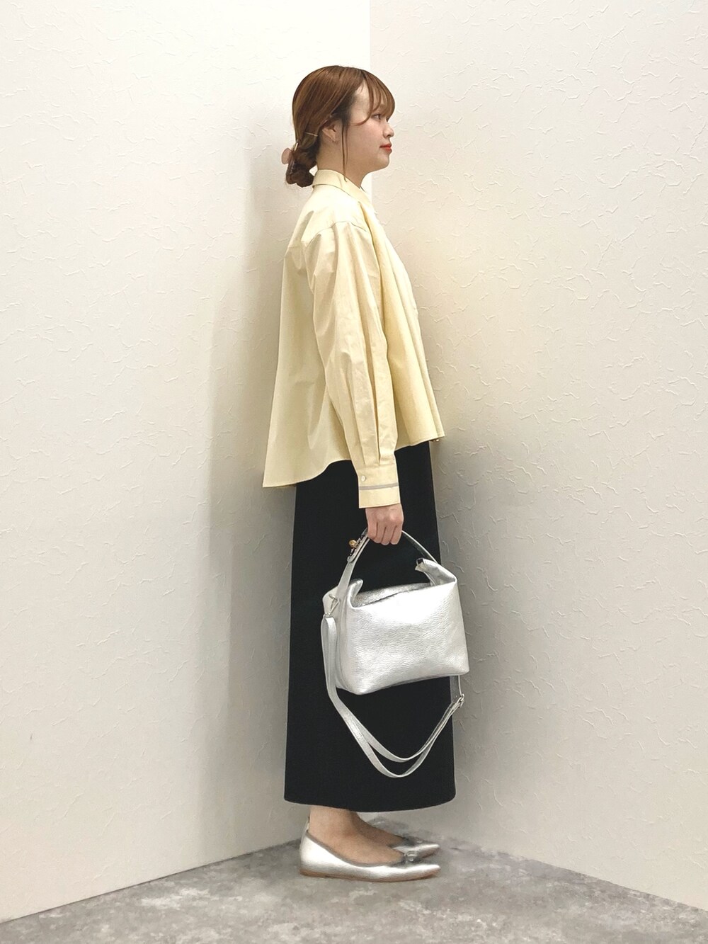 シルバー系のショルダーバッグ、イエロー系のシャツ/ブラウス、ブラック系のスカートを着用したレディースの春コーディネートの5枚目の写真