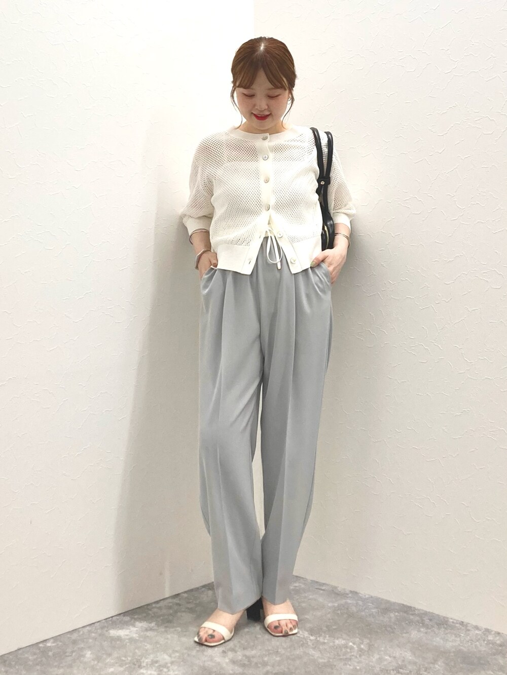 ホワイト系のカーディガン/ボレロ、グレー系のその他パンツ、ブラック系のボストンバッグを着用したレディースの春コーディネートの9枚目の写真