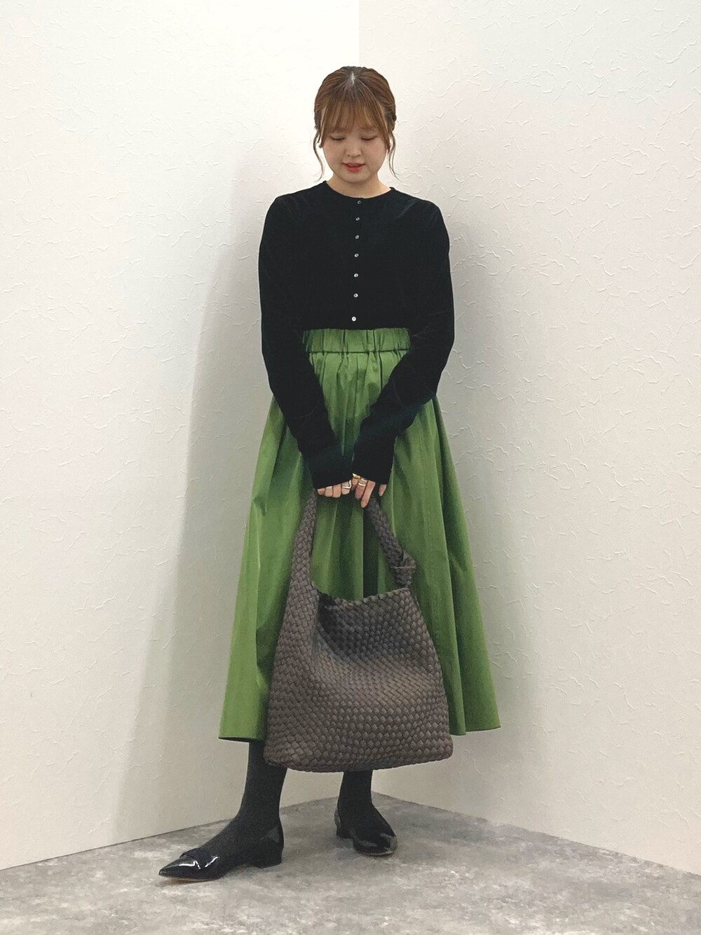 ブラック系のカーディガン/ボレロ、グリーン系のスカート、グレー系のショルダーバッグを着用したレディースの秋コーディネートの6枚目の写真