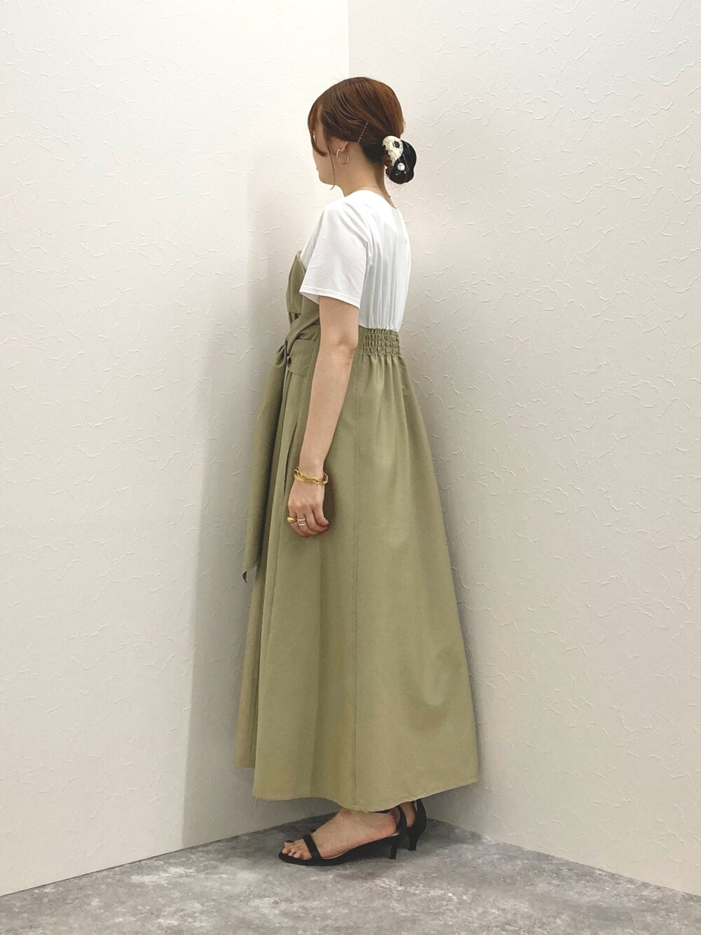 グリーン系のワンピース、ブラック系のサンダル、ブラック系のかごバッグを着用したレディースの春コーディネートの4枚目の写真