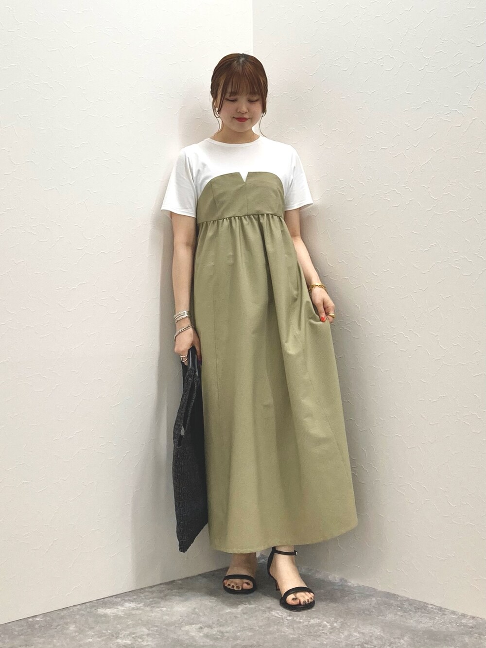 グリーン系のワンピース、ブラック系のサンダル、ブラック系のかごバッグを着用したレディースの春コーディネートの8枚目の写真