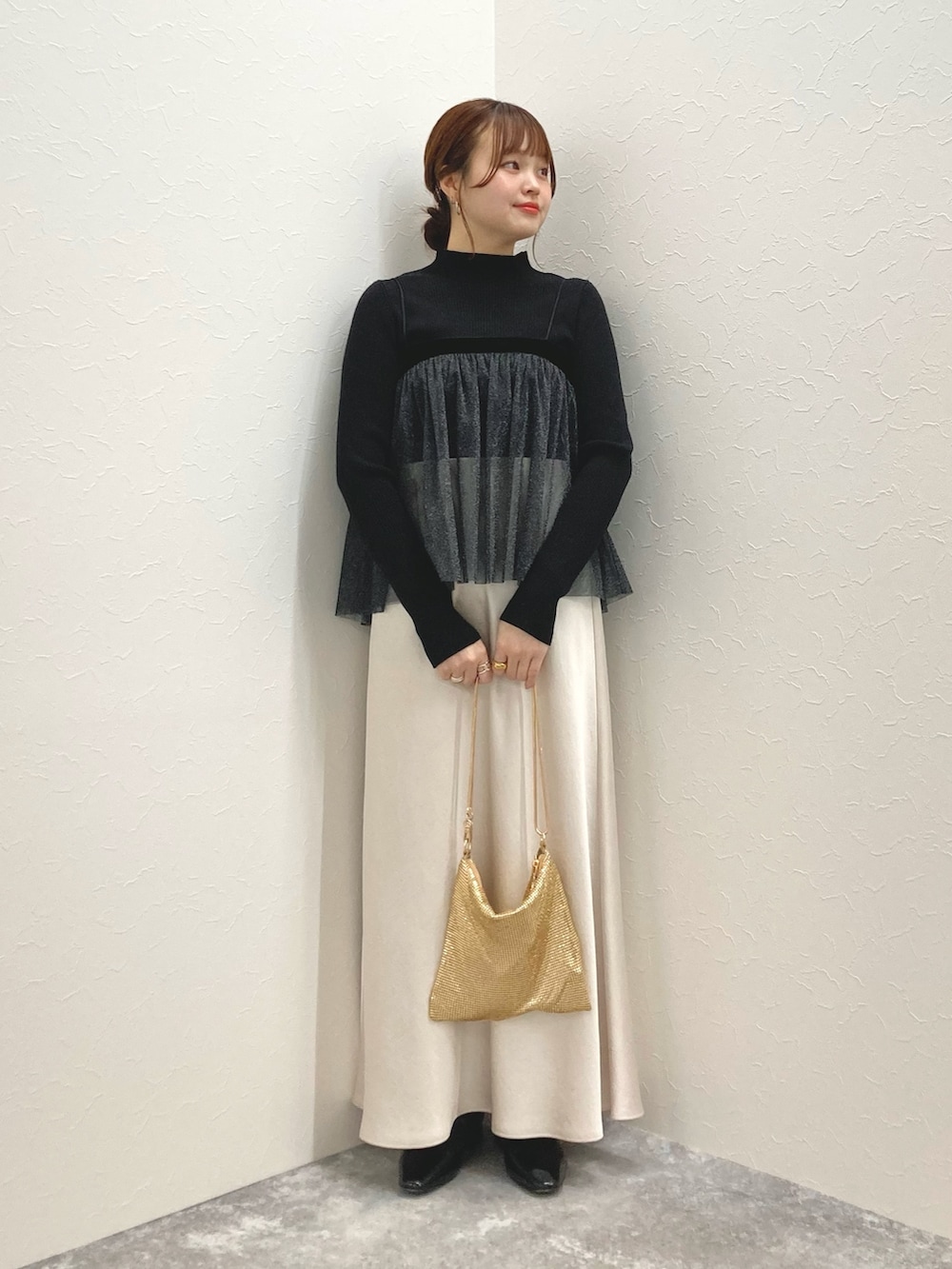 ホワイト系のニット/セーター、ブラック系のシャツ/ブラウス、ゴールド系のクラッチバッグを着用したレディースの秋コーディネートの7枚目の写真