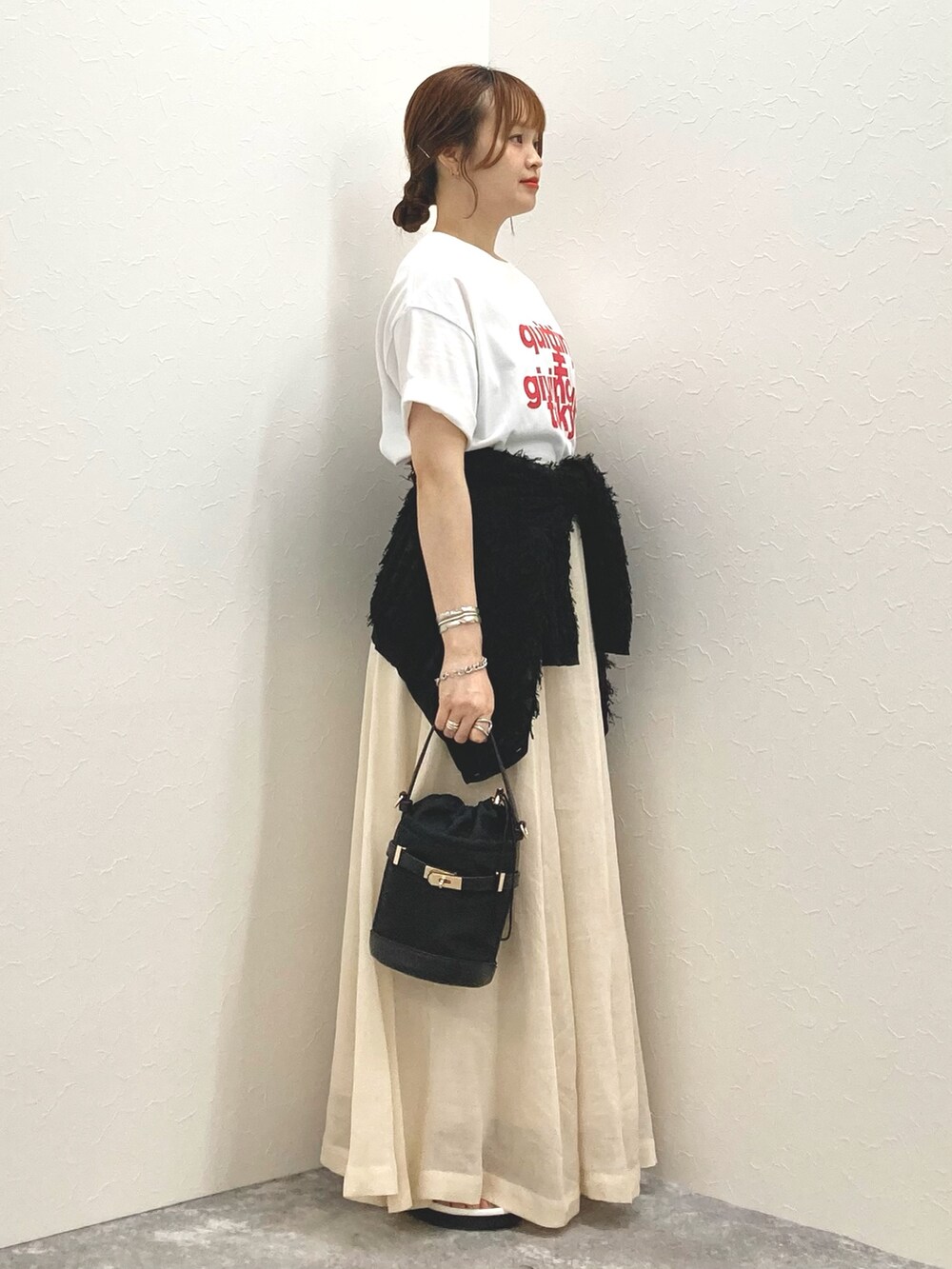 ホワイト系のTシャツ/カットソー、ベージュ系のスカート、ブラック系のカーディガン/ボレロを着用したレディースの夏コーディネートの4枚目の写真