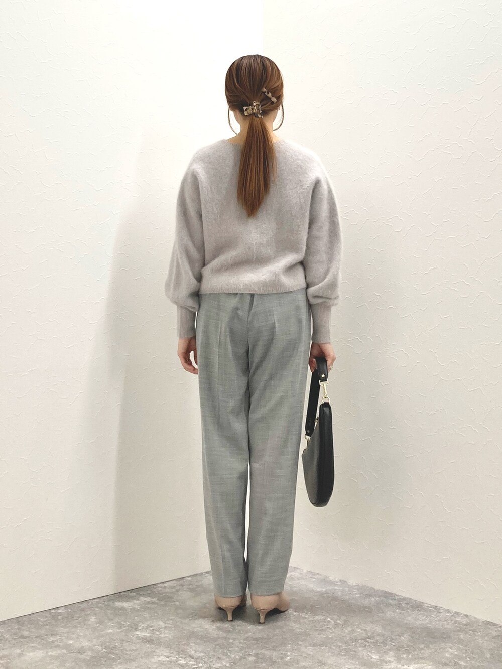 ベージュ系のニット/セーター、ブラック系のショルダーバッグ、グレー系のその他パンツを着用したレディースの冬コーディネートの4枚目の写真